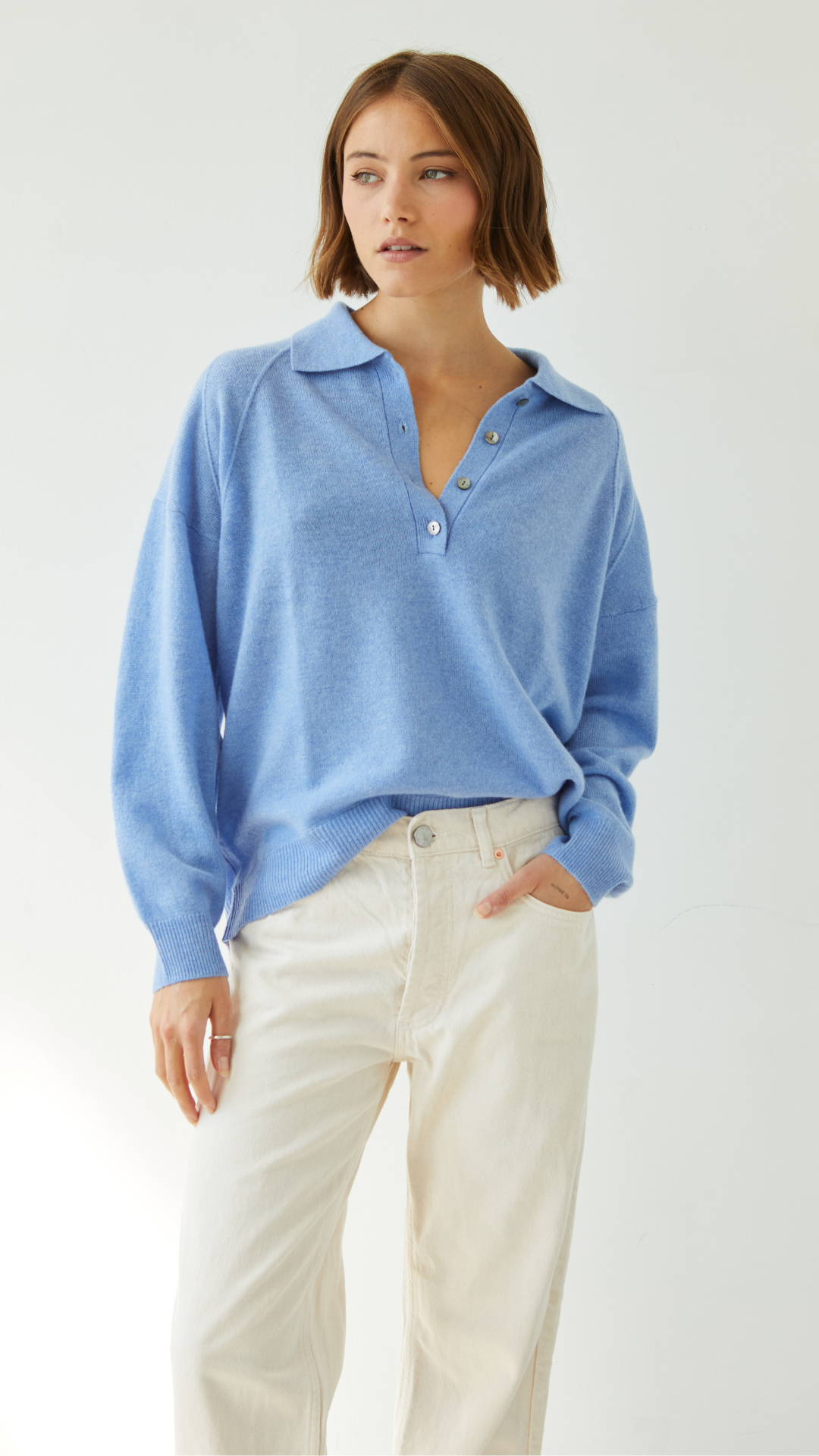 light blue collared sweater with button details, paired with cream trousers