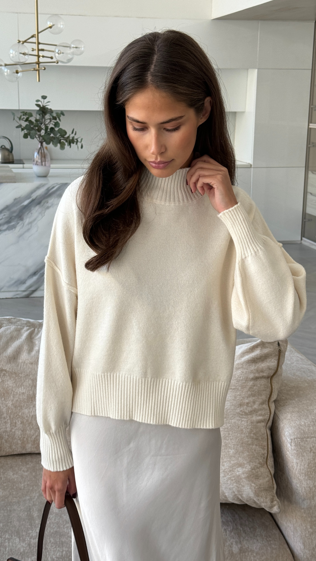 cream-coloured knit sweater paired with a white satin skirt
