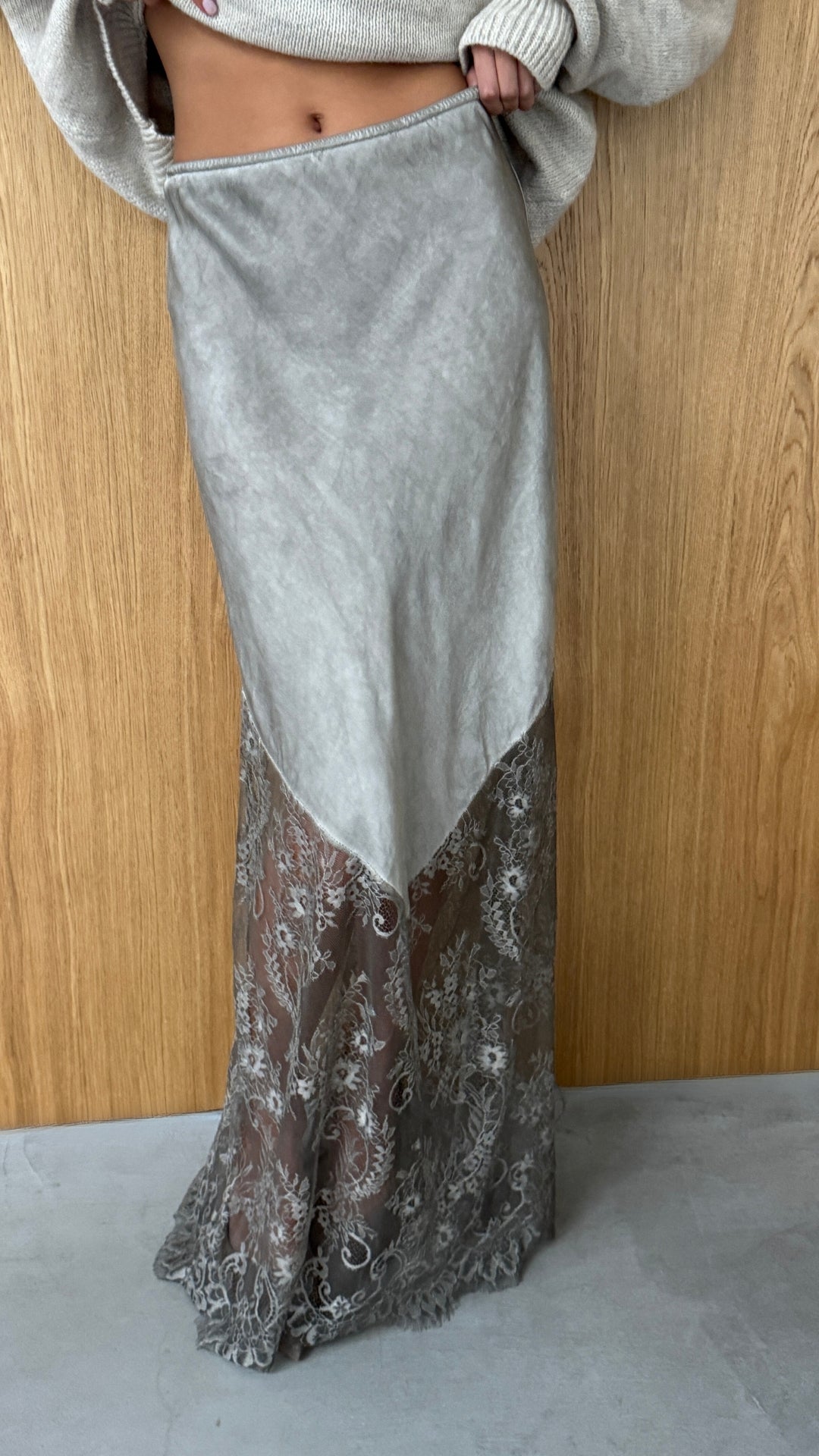 grey satin skirt with intricate lace details along the hem. The skirt has a sheer lace overlay at the bottom