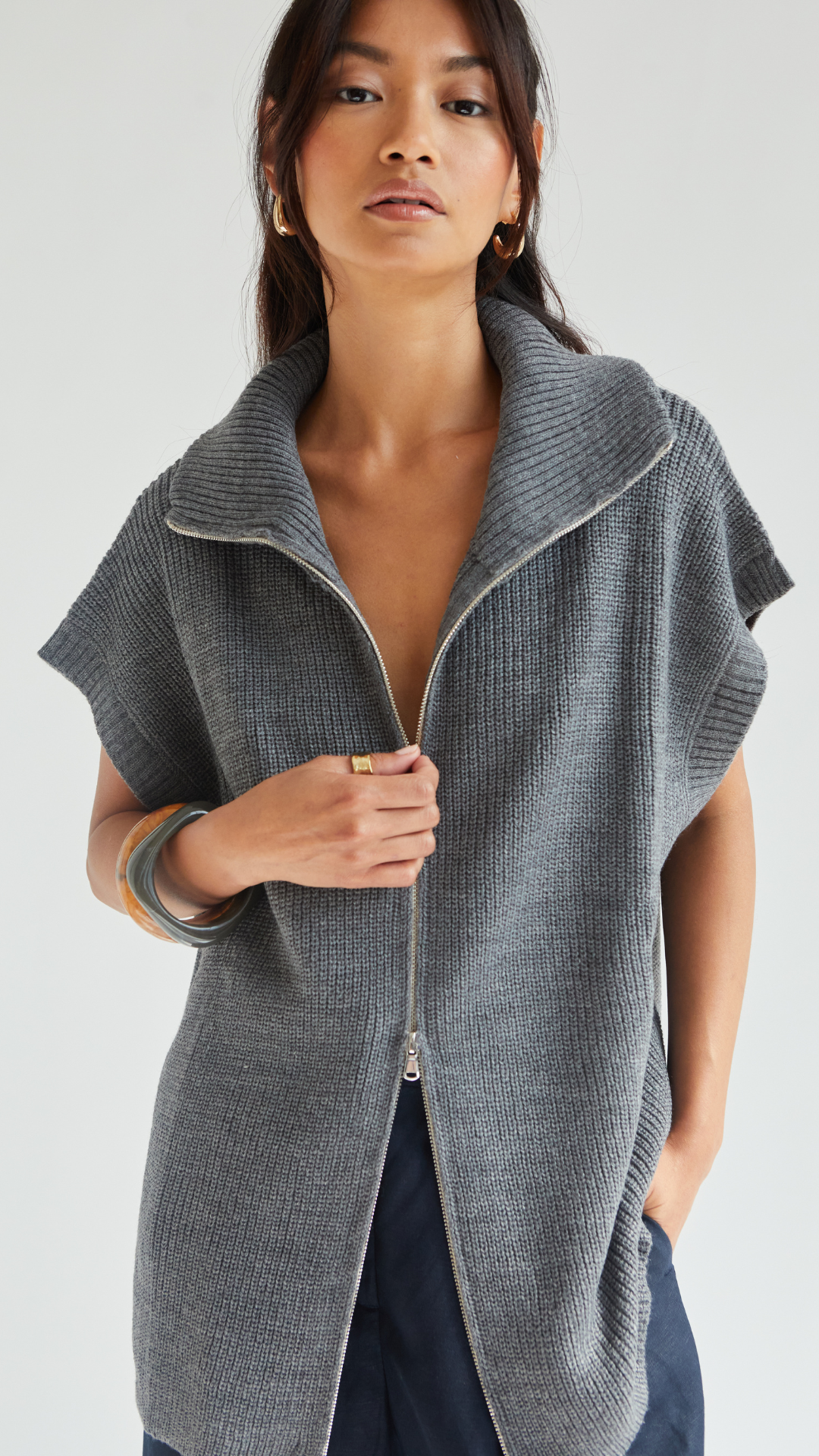 grey knitted cardigan with a high zip-up collar, styled with short sleeves