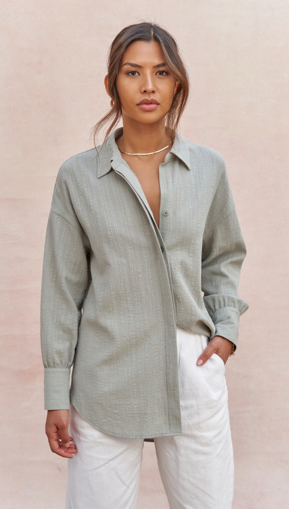 light sage green textured button-up shirt paired with white trousers