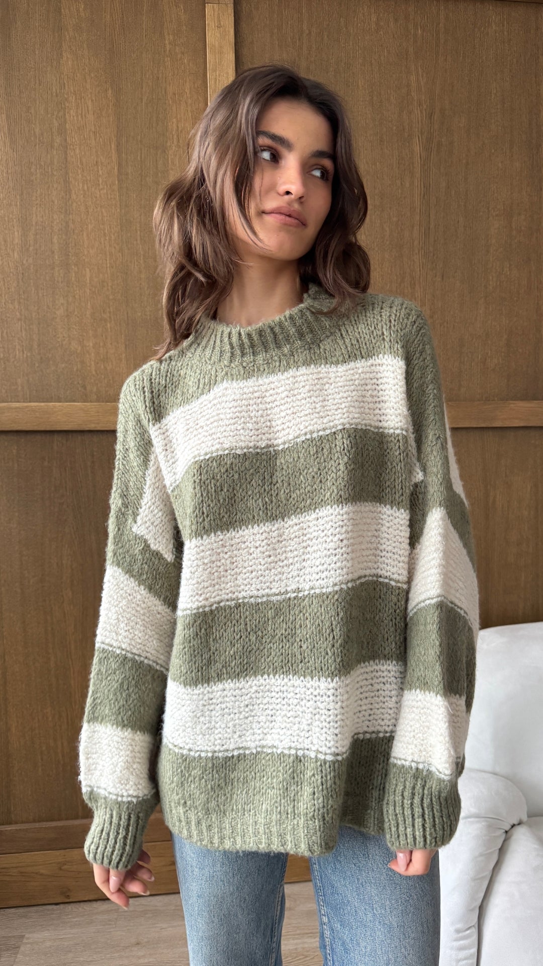 green and white striped knit sweater, paired with light blue jeans