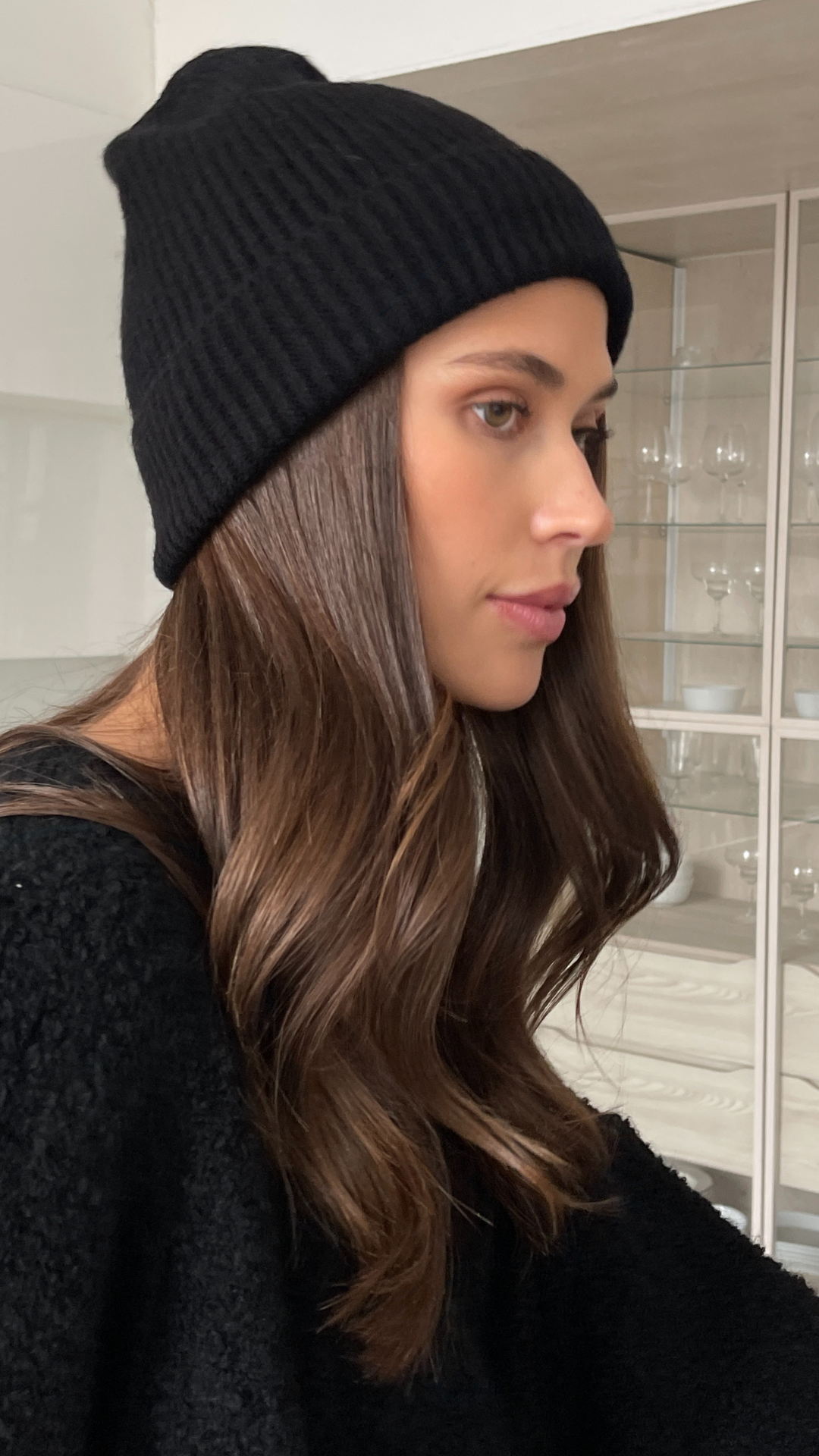 black ribbed beanie and a black textured sweater