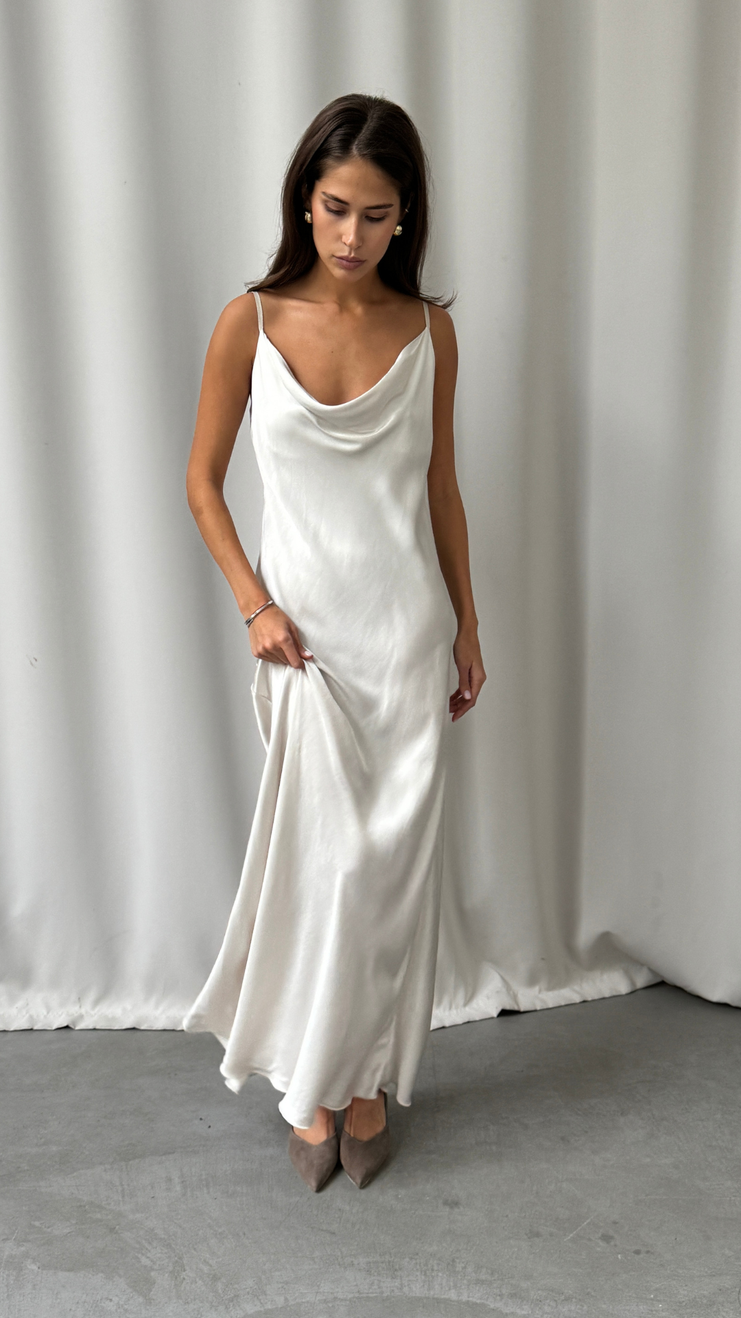 ivory satin slip dress featuring a draped cowl neckline and thin spaghetti straps, styled with taupe pointed-toe heels and minimal jewellery