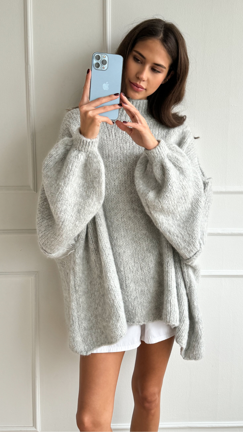 oversized light grey knit sweater with voluminous sleeves, styled with white shorts