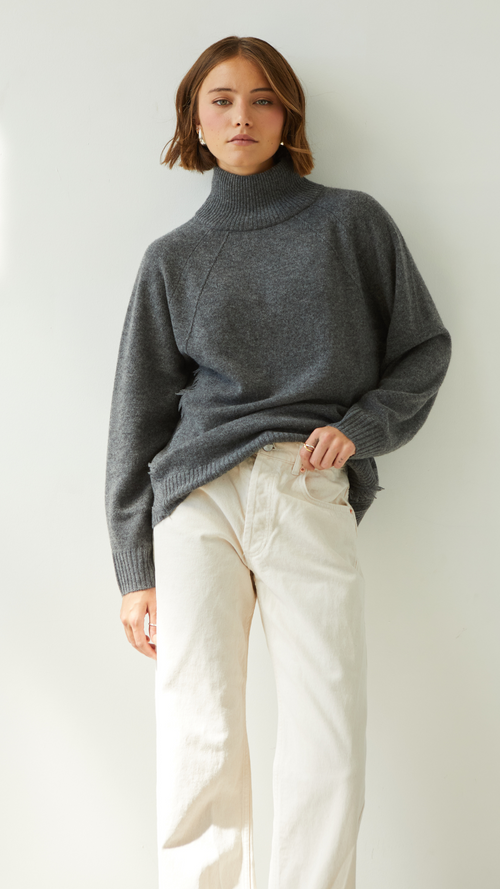 grey turtleneck sweater paired with cream trousers