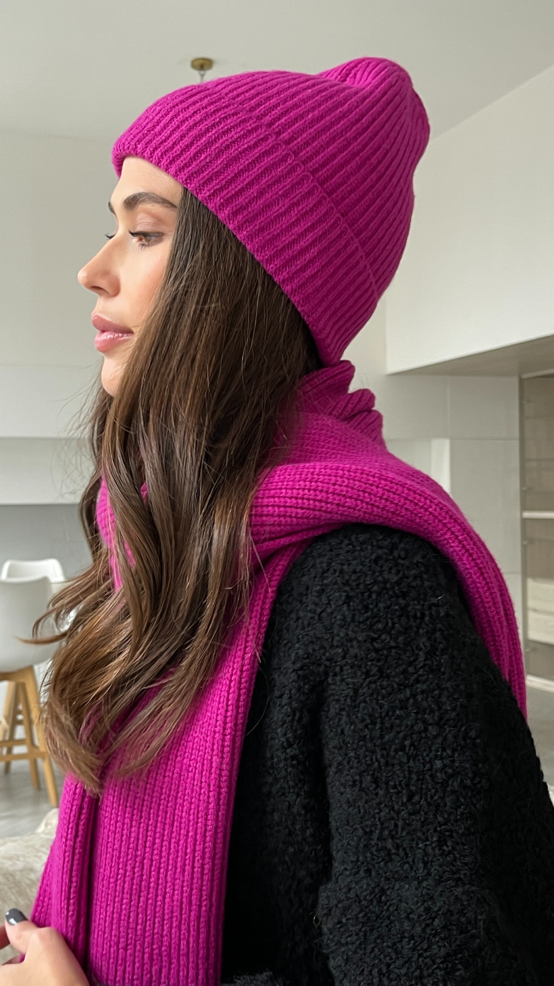 vibrant pink ribbed beanie and matching scarf, paired with a black textured sweater