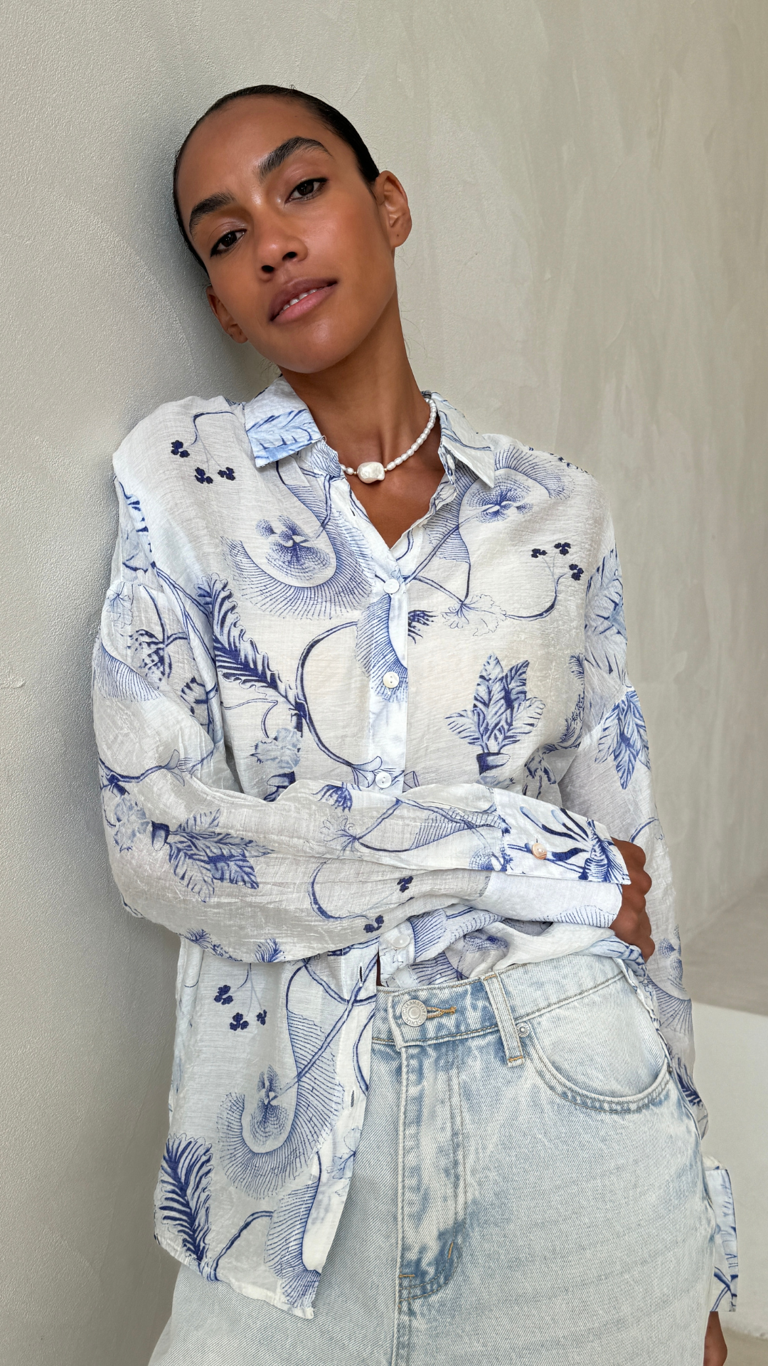 white button-up shirt with blue botanical prints, styled with light denim jeans
