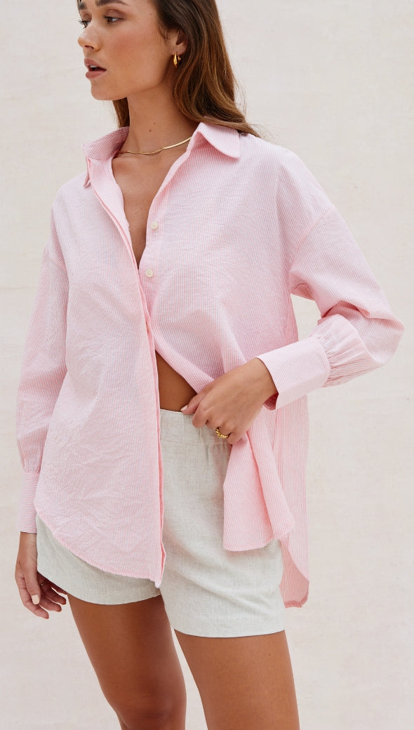light pink oversized button-up shirt paired with beige shorts