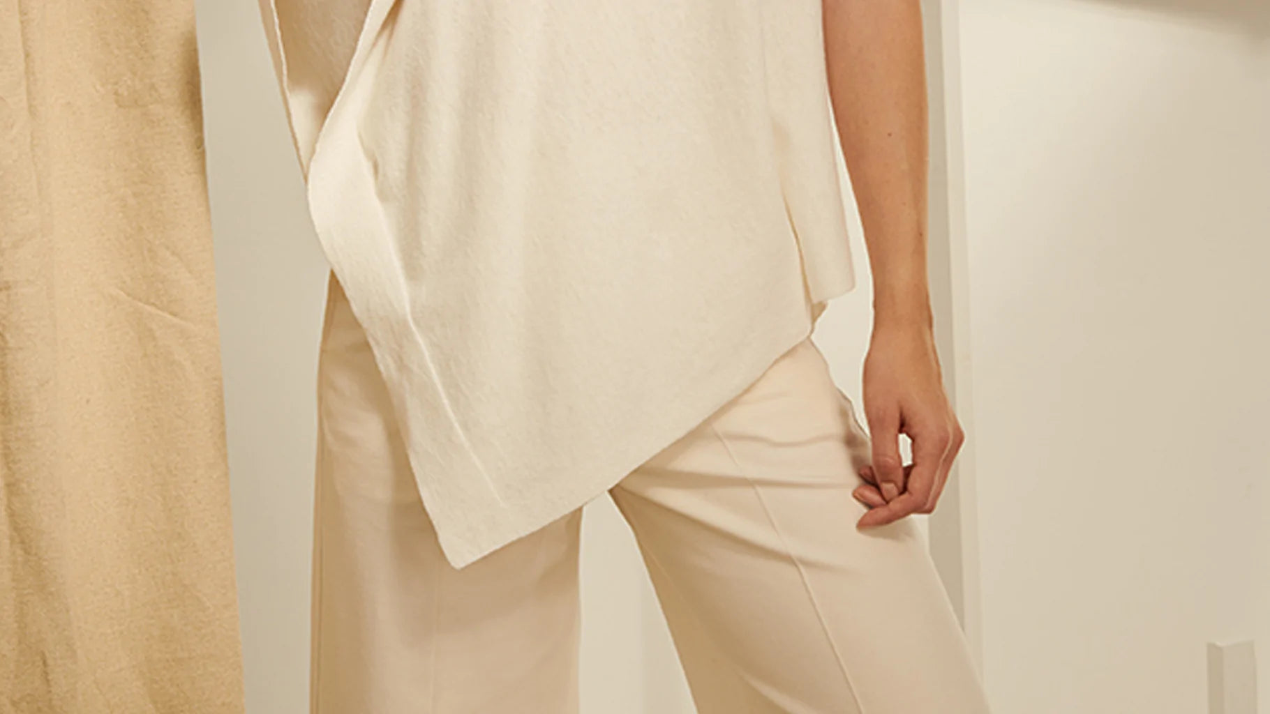 cream outfit featuring an asymmetrical hem top paired with tailored cream trousers