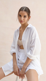 white textured button-up shirt with matching shorts, paired with a beige crop top