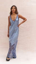 blue slip dress featuring a plunging lace-trimmed neckline and a sheer lace hem, styled with black sandals
