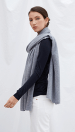 navy long-sleeve top with a light grey scarf, paired with white trousers