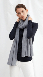 navy long-sleeve top with a light grey scarf, paired with white trousers
