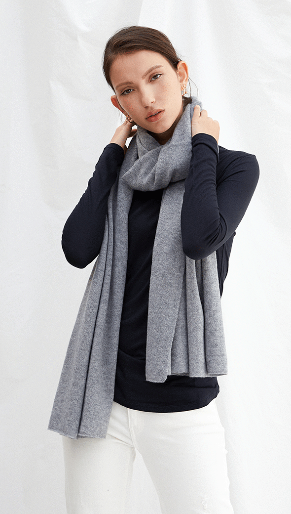 navy long-sleeve top with a light grey scarf, paired with white trousers
