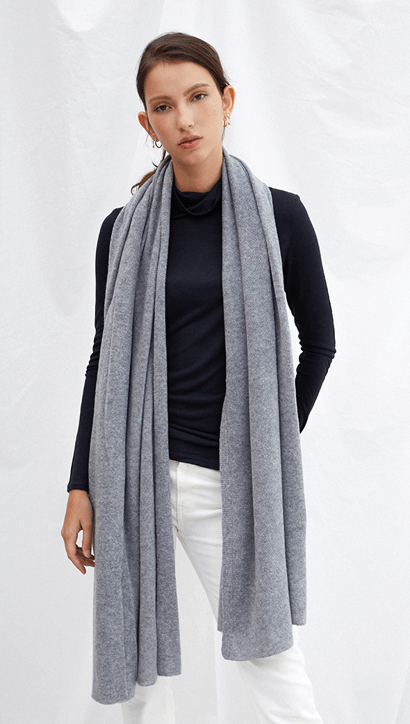 navy long-sleeve top with a light grey scarf, paired with white trousers